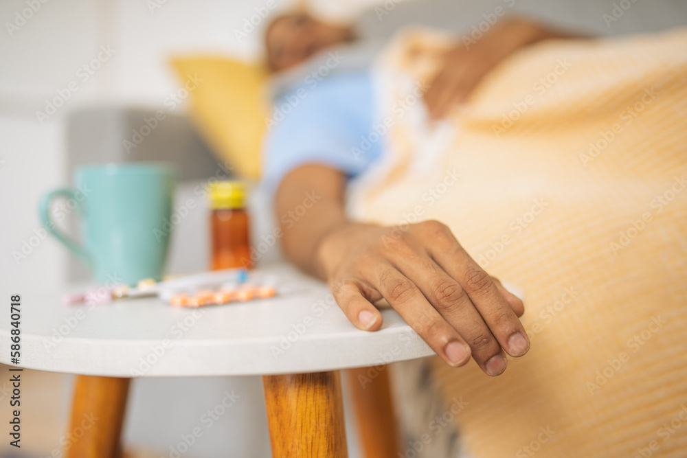 Hand of a sleeping man on the side table with pills. Hand of a sleeping man on the side table with pills.