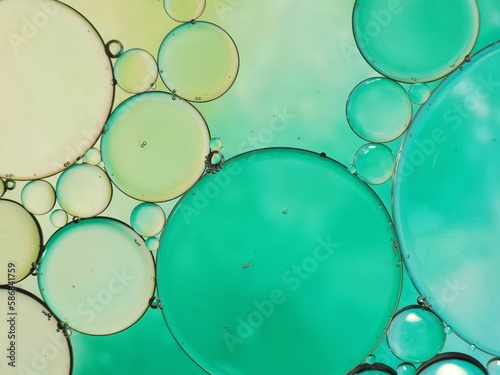 gotas de aceite que formaron una imagen abstracta de círculos brillantes en tonos verde y turquesa. burbujas de aceite para fondo abstracto