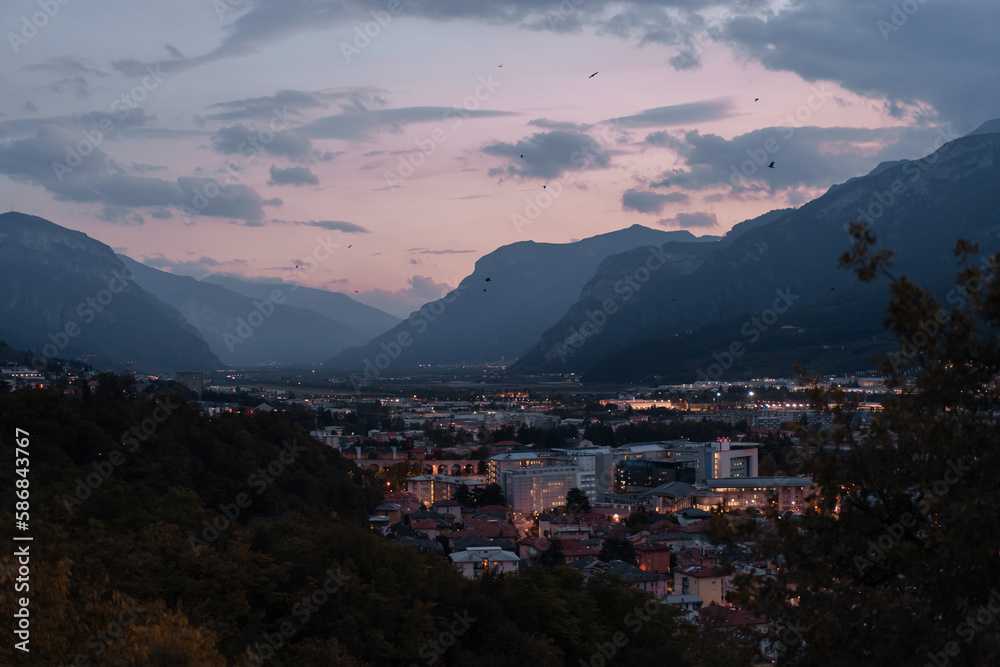 A panoramic night view of Trento, Italycity from above. Evening  Aerial view of town between mountains and river with the warm evening lights turned on. High dynamic range picture.