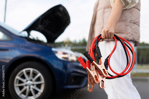 Photos close-up of a car voltmeter in the hands of a woman against the background of a