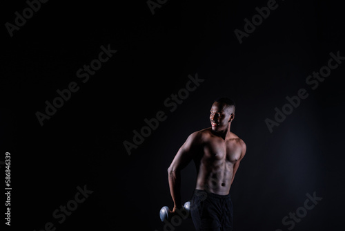Portrait of a happy african man with dumbbells over red and black background