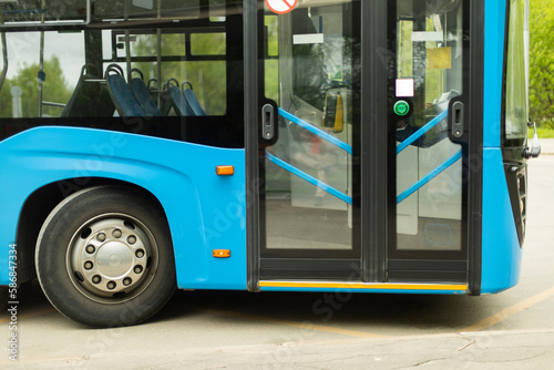Blue bus. Public transport at bus stop. Details of transport infrastructure.