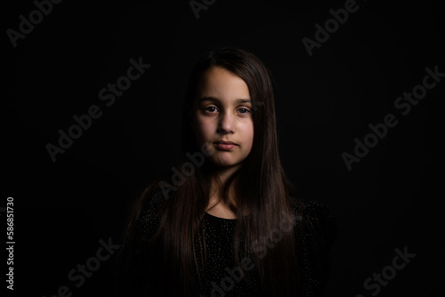 Closeup portrait of happy little girl isolated on black background
