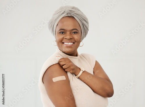 Black woman, smile and covid plaster on arm in studio for injection with medical insurance. Portrait of African female happy on a white background with vaccine, safety compliance and mockup space