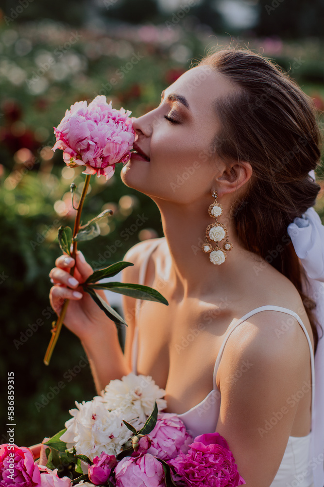 Naklejka premium young woman with pink peonies 