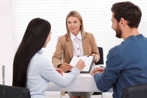 Couple signing contract in real estate agent's office