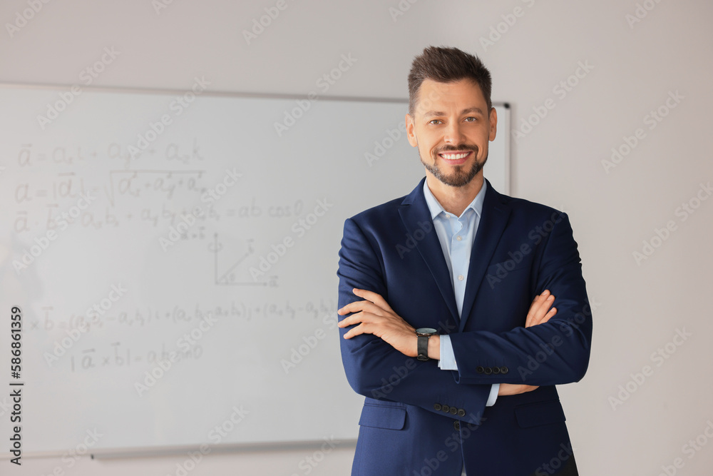 Happy teacher at whiteboard in classroom during math lesson Happy teacher at whiteboard in classroom during math lesson