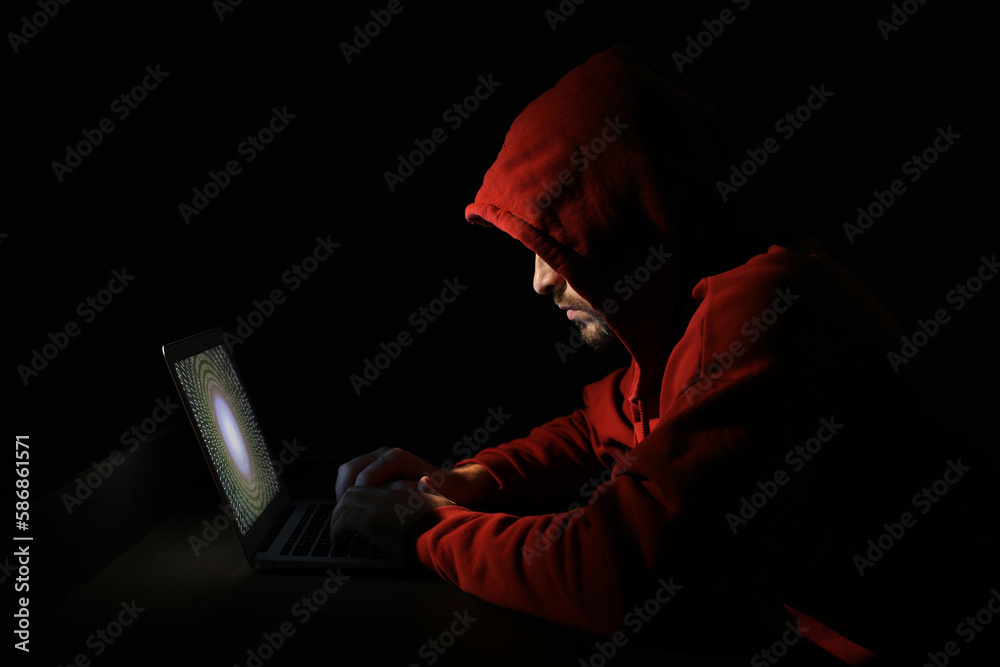 Hacker working with laptop in dark room. Cyber attack Hacker working with laptop in dark room. Cyber attack