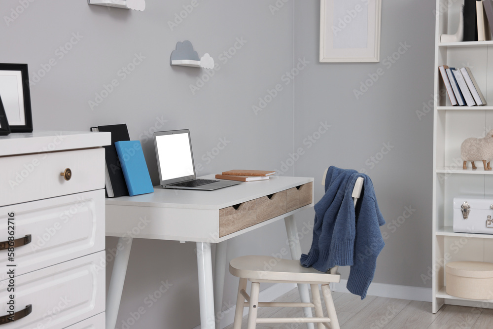 Stylish workplace with laptop on white desk. Home office interior Stylish workplace with laptop on white desk. Home office interior