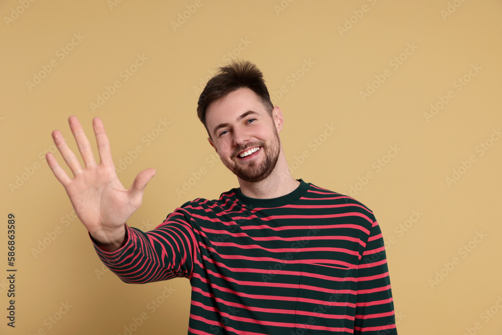 Man giving high five on beige background Man giving high five on beige background