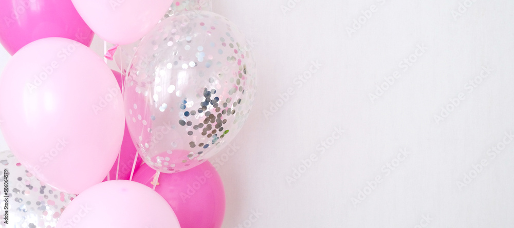 A bundle of pink and transparent air balloons with silver confetti, copy space for your text, tender pastel colors for a girlish party A bundle of pink and transparent air balloons with silver confetti, copy space for your text, tender pastel colors for a girlish party