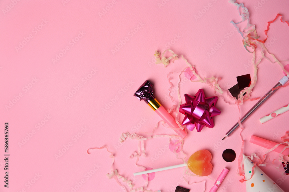 Party blower, lollipop and festive decor on pink background, flat lay. Space for text Party blower, lollipop and festive decor on pink background, flat lay. Space for text