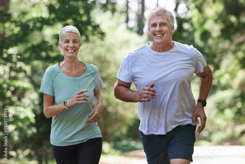 Senior couple, exercise and running outdoor for happy workout and training for fitness. Elderly man and woman laugh for cardio, health and wellness on run in nature forest for healthy retirement