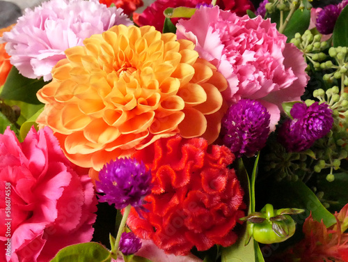 Bouquet of flowers in bright colors, pink, red, orange. With among others, dahlias, carnations and ivy flowers.