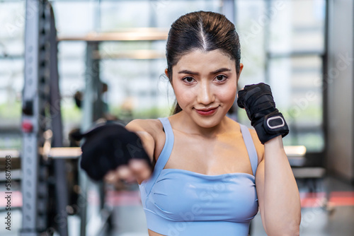 Smiling asian athletic woman punching the air with her fists training warm-up before boxing workout at gym club. Sports. Activity. Motivation. Confidence, working out on boxing moves.