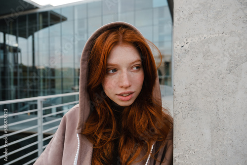 Redhead girl looking aside while standing outdoors © Drobot Dean