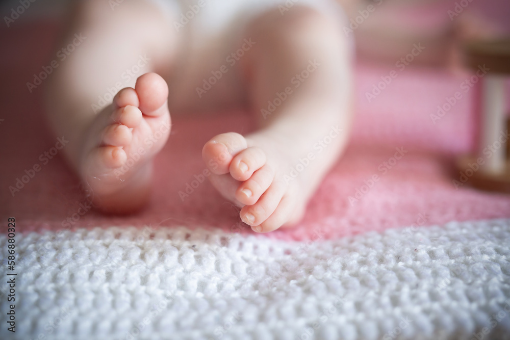 Baby's feet on a pink and white blanket Baby's feet on a pink and white blanket