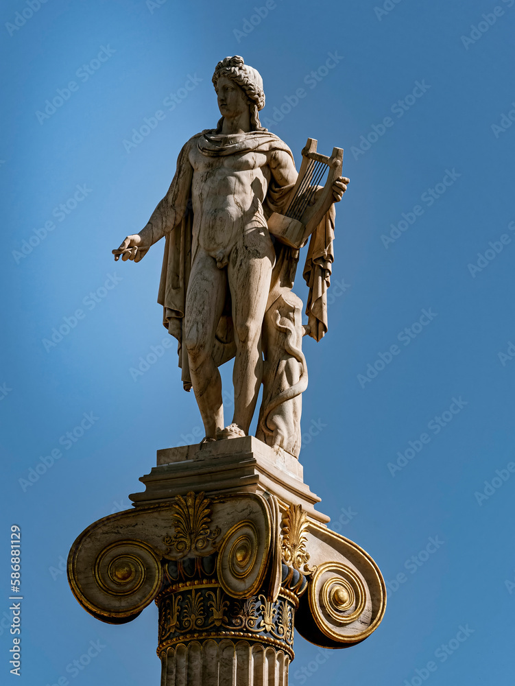 Statue of Apollo, ancient Greek god of fine arts, wearing a tunic and holding a lyre. Travel to Athens, Greece.