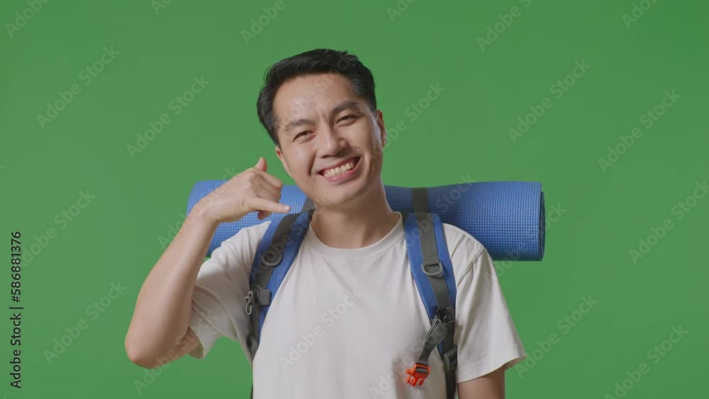 Close Up Of Asian Male Hiker With Mountaineering Backpack Smiling And Showing Call Me Gesture While Standing On Green Screen Background In The Studio
Close Up Of Asian Male Hiker With Mountaineering Backpack Smiling And Showing Call Me Gesture While Standing On Green Screen Background In The Studio