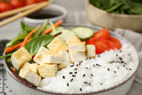 Delicious poke bowl with vegetables, tofu and mesclun, closeup