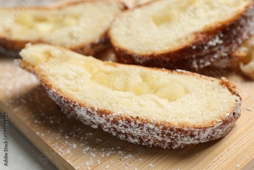 Pieces of delicious yeast dough cake on wooden board, closeup