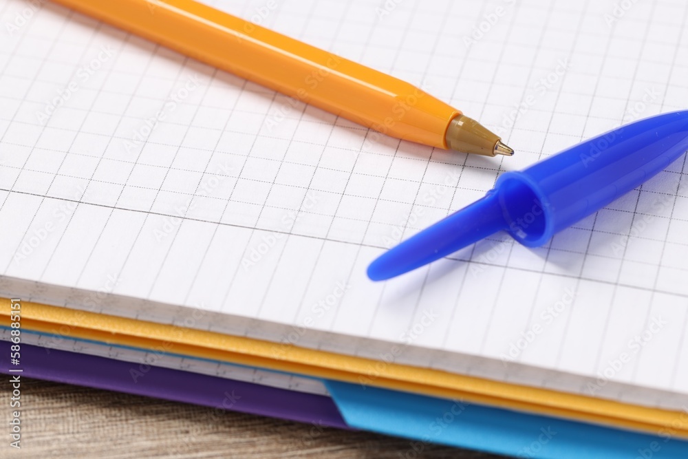 Ballpoint pen and notebook on wooden table, closeup Ballpoint pen and notebook on wooden table, closeup