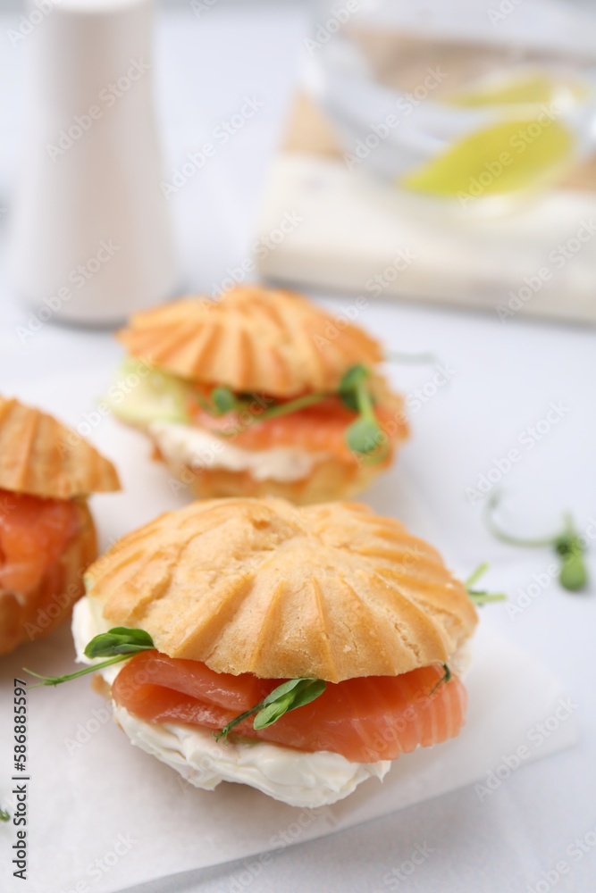 Delicious profiteroles with cream cheese and salmon on white table, closeup Delicious profiteroles with cream cheese and salmon on white table, closeup