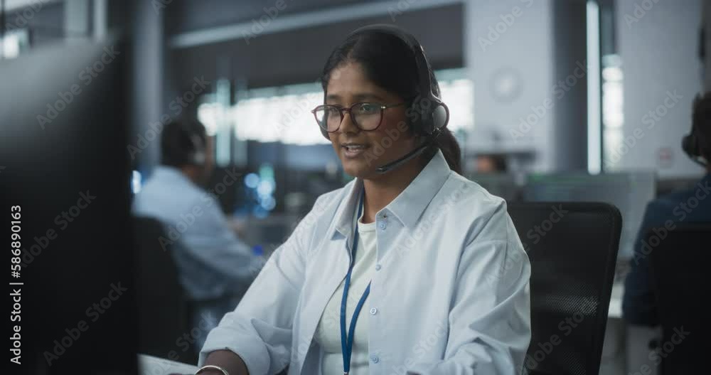 Portrait of a Help Desk Specialist Having a Conversation on a Call, Providing Technical Support to Client Experiencing Software Issues. Indian Female Using a Headset to Talk with a Tech Team