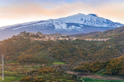 amazing mountain sunset landscape of green mountains and hills, old highland town and snow top mountain on backgroud