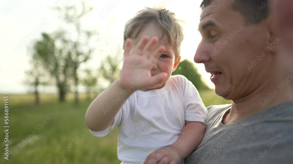Happy family. Father and son are playing in the park. Baby in the arms of his father. Cheerful baby boy with father walk outdoors in the park. A smile on a child's face. Family team outdoors in park Happy family. Father and son are playing in the park. Baby in the arms of his father. Cheerful baby boy with father walk outdoors in the park. A smile on a child's face. Family team outdoors in park