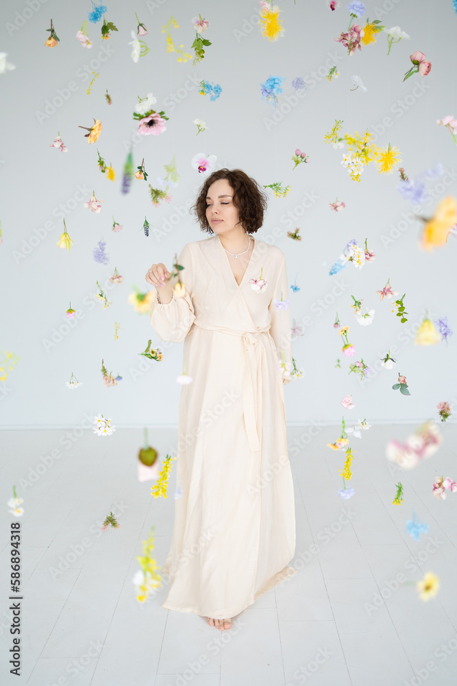 brunette girl in a long beige dress dances among the soaring flowers brunette girl in a long beige dress dances among the soaring flowers