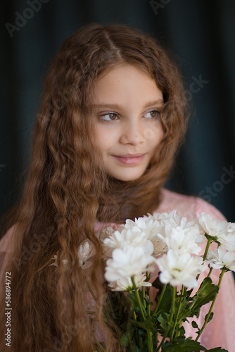 close-up portrait of a girl in a pink dress with white chrysanthemums