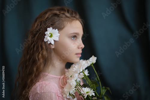 close-up portrait of a girl in a pink dress with white chrysanthemums