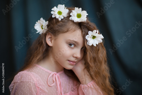 close-up portrait of a girl in a pink dress with white chrysanthemums