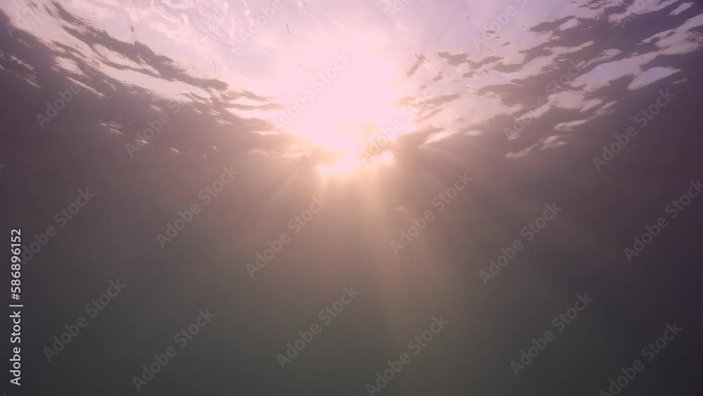 Slow motion, Orange rays of the sun break through the surface of the