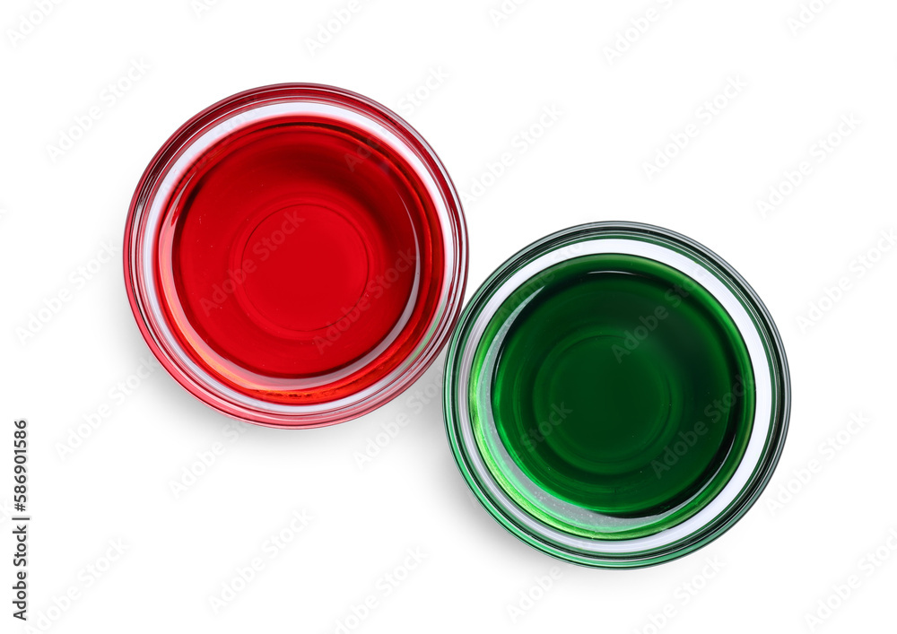 Glass bowls with red and green food coloring on white background, top view Glass bowls with red and green food coloring on white background, top view