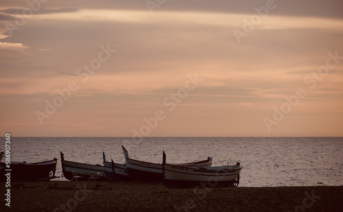 Fishing boat on the shore of the beach.  Sea in the background with space for text. Old fishing boats on the sand. © Karen Images