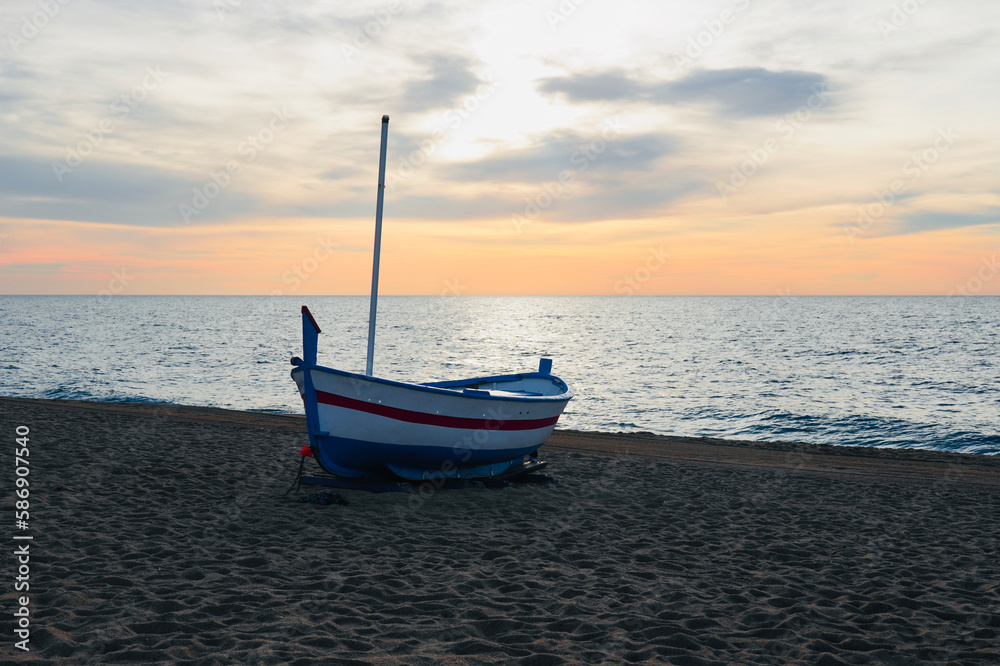 Fishing boat on the shore with sunrise sky.
