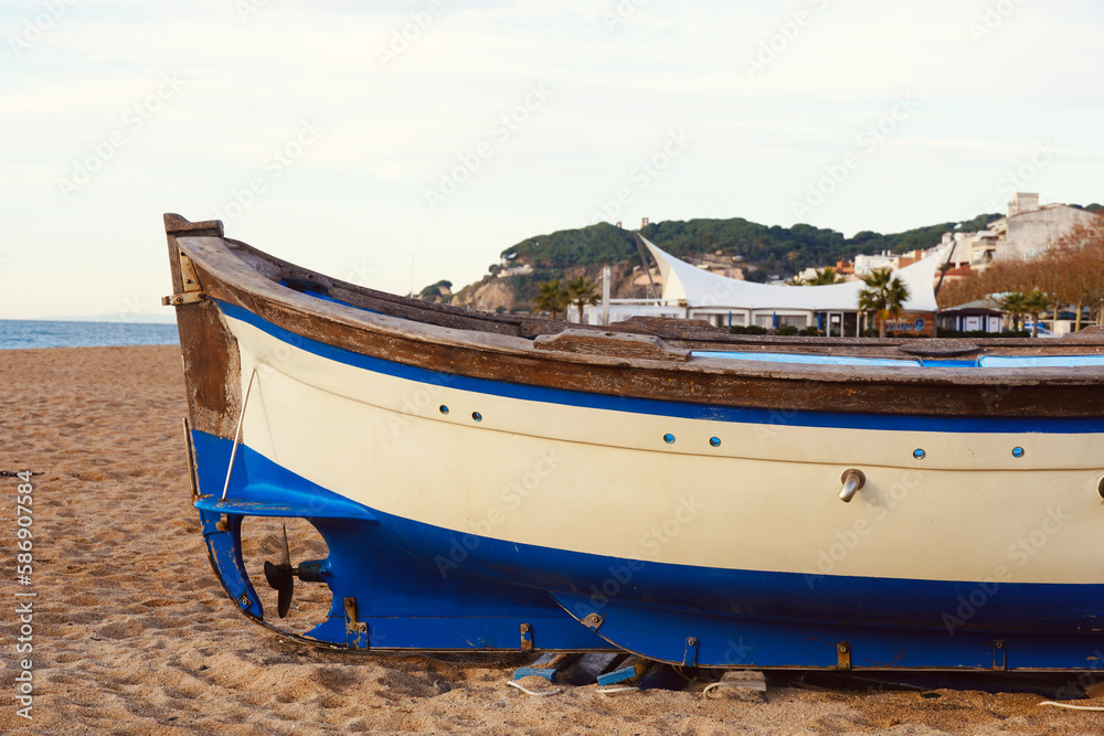 Calella beach at sunrise time with boats on the sand near the seashore. Perfect place for vacations near the touristic Costa Brava. Barcelona, Spain.