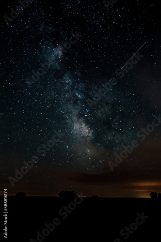 the milky way in the countryside with nebulae and a meteor trace on the image
