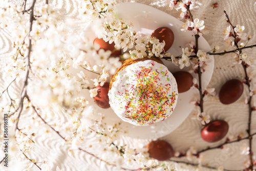 Easter cake and painted eggs. Blooming bouquet laying on the table near.