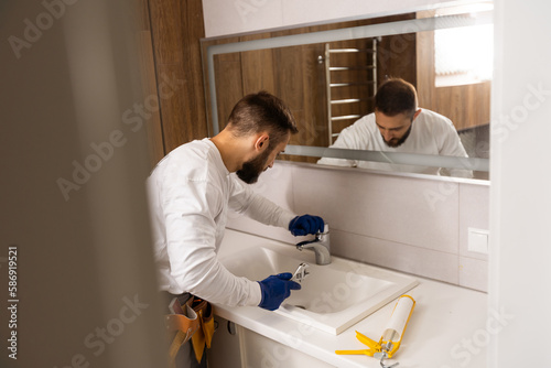 a worker installs a wash basin in a bathroom.