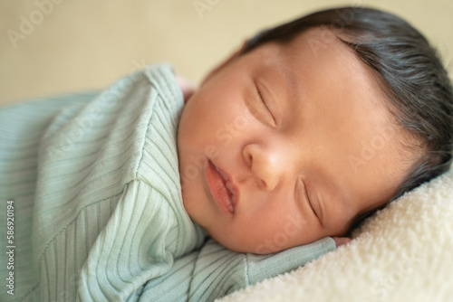 Obraz na płótnie Newborn baby infant with dark hair lying on side sleeping awaking open eyes. Cute little Middle eastern child on blanket. Tranquil scene close up w salonie