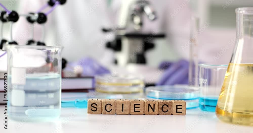Word science with microscope and liquids in flask. Science education and laboratory research and development concept Word science with microscope and liquids in flask. Science education and laboratory research and development concept