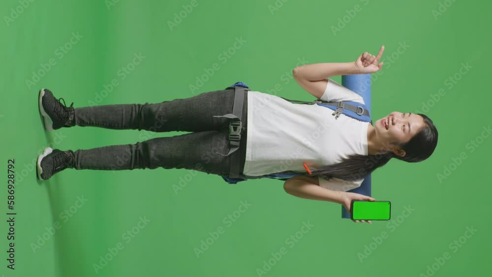 Full Body Of Asian Female Hiker With Mountaineering Backpack Showing Mock Up Green Screen Smartphone And Pointing To Side While Standing On Green Screen Background In The Studio
Full Body Of Asian Female Hiker With Mountaineering Backpack Showing Mock Up Green Screen Smartphone And Pointing To Side While Standing On Green Screen Background In The Studio