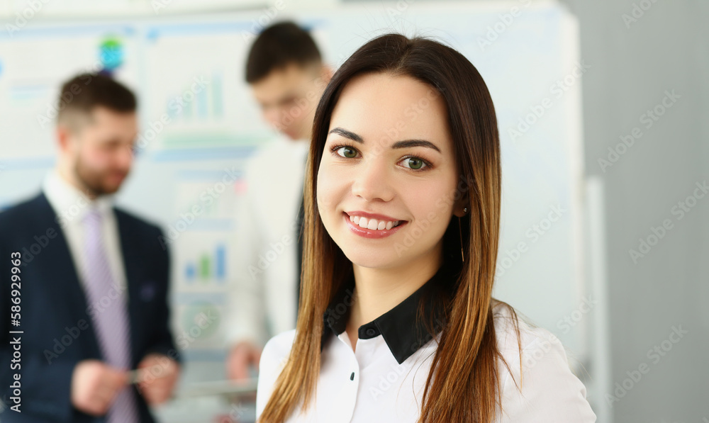 Portrait of smiling businesswoman in the background business partners. Successful career and internship in modern office Portrait of smiling businesswoman in the background business partners. Successful career and internship in modern office