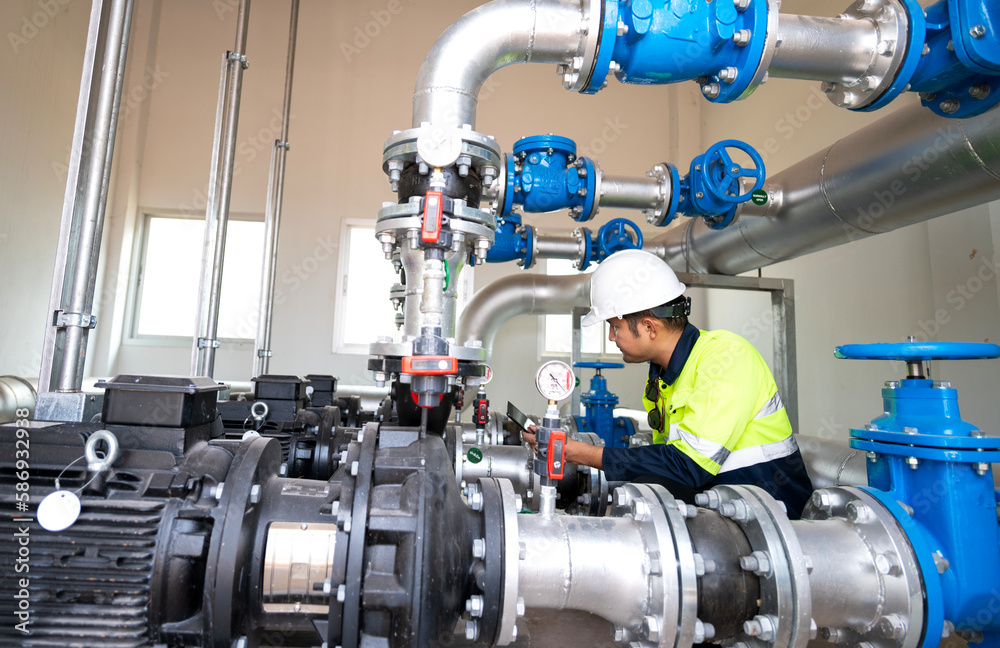 Asia oil and gas production control engineer or supervisor with digital pad monitoring natural gas supply and distribution in refinery Installation view of natural gas refinery pipes