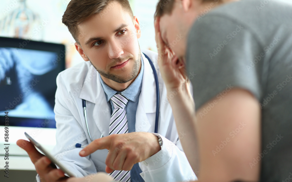 Obraz premium Doctor with tablet consults patient suffering from mental stress and depression. Medical diagnosis of fatal disease and communication to patient