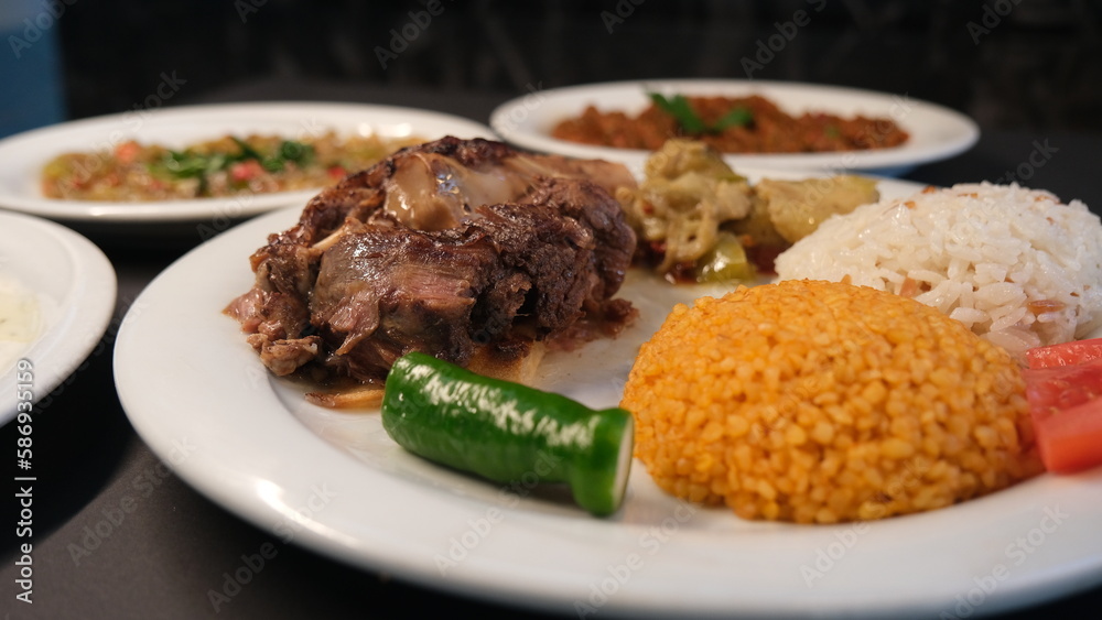 Beef breast ribs served with rice and appetizers on a serving plate