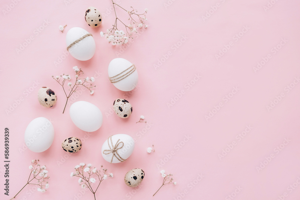Composition with Easter eggs and spring flowers on pink background. Minimal easter concept.
